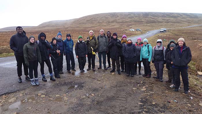 Staff and student group photo in front of moorland in the Peak District