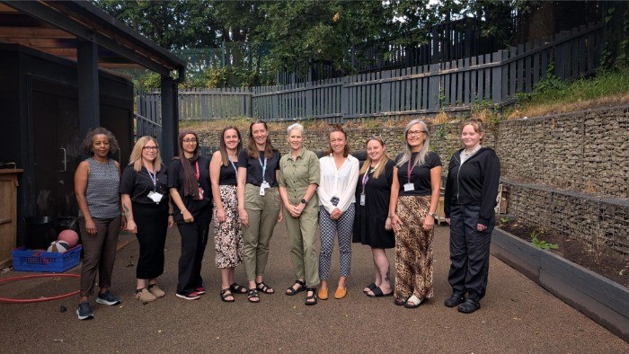 The team from the Meadows nursery, they are stood in a line in the nursery garden.