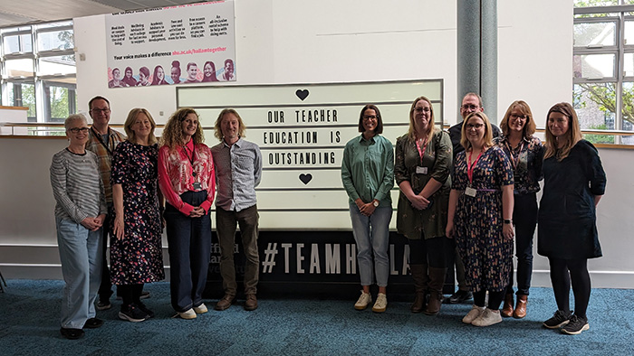 Team from Sheffield Institute of Education stood in front of a board which says 'our teacher education is outstanding'.