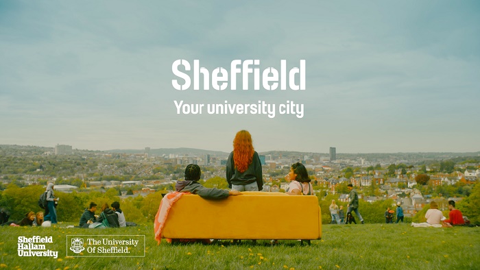 Yellow sofa with students sat on it overlooking Sheffield city scene