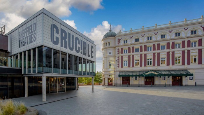Tudor Square in Sheffield, The Crucible Theatre stands on the left and the Lyceum on the right, against a blue sky. 