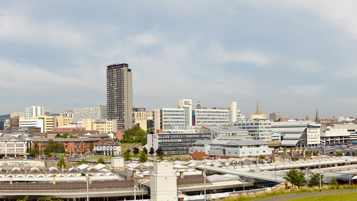 Sheffield train station in the foreground with Sheffield Hallam University in the background