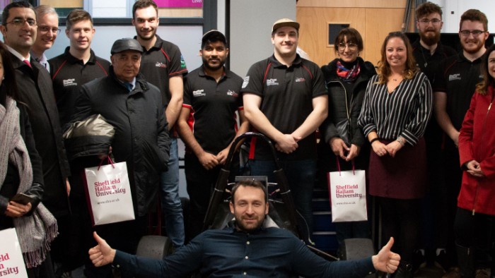 Delegates from Azerbaijan visiting SHU Racing photographed next to the racing car