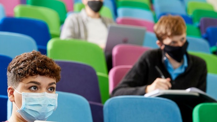 Socially distanced students being taught in a lecture theatre on campus