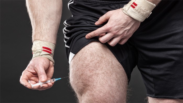 An rugby player injecting himself in the leg