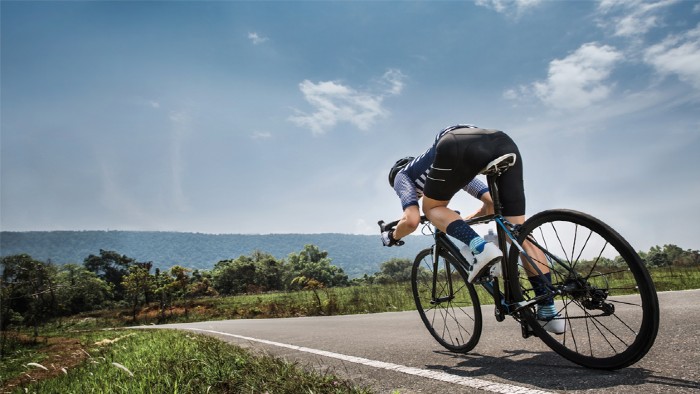 A cyclist going downhill in the conventional position