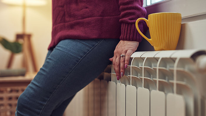 Woman leaning against a radiator