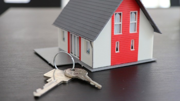 A model house with keys in front on a table top