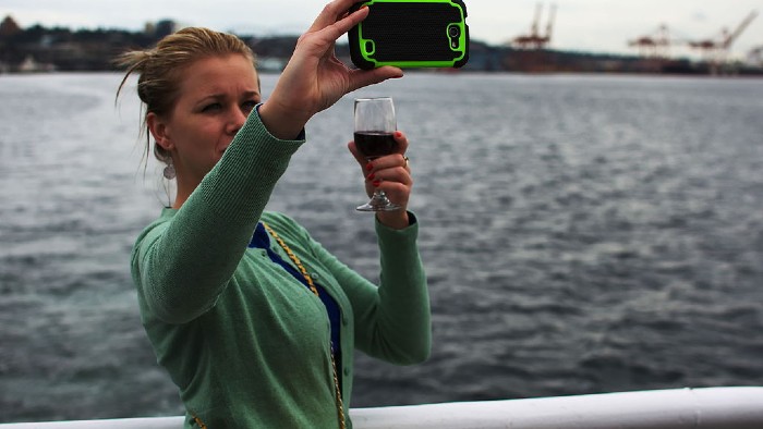 Woman holding wine glass taking a selfie
