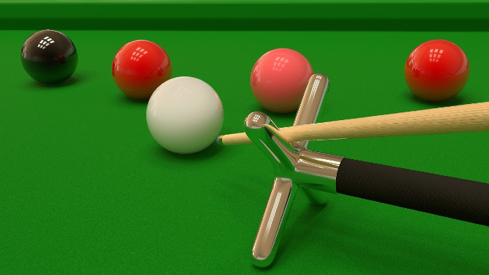 A snooker table showing two red balls, a pink and a black ball with a cue being lined up to take a shot.