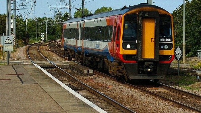 a modern UK passenger train pulling into a station