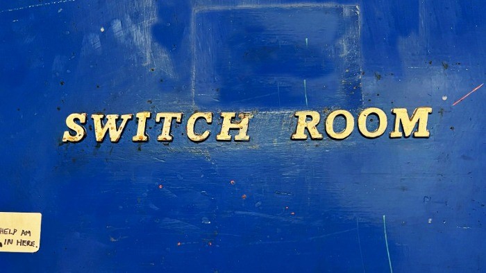 Letters spelling 'Switch Room' on a worn blue background