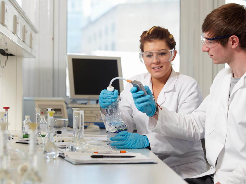 Students in lab coats preparing experiment