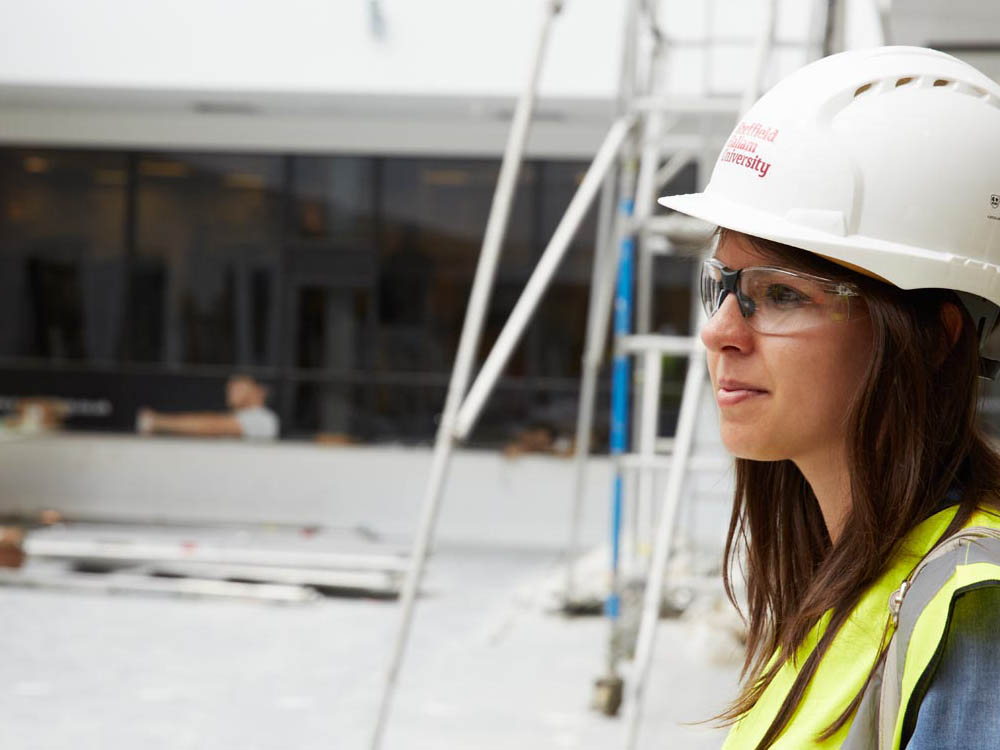 Woman in hard hat on building site