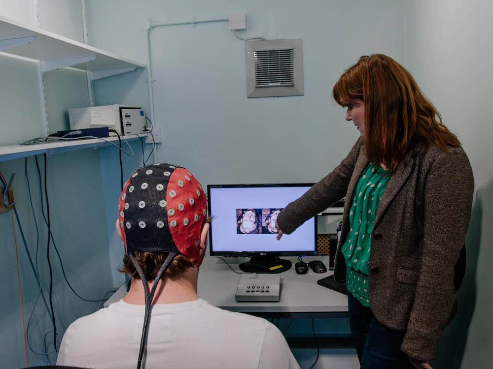 Student in brain activity scanning skull cap