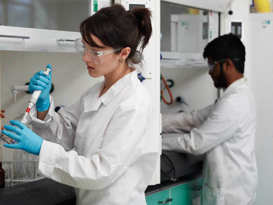 Students in lab coats preparing experiments