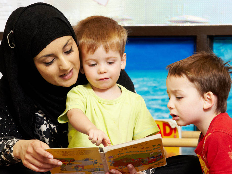 Tutor supervising young children teaching
