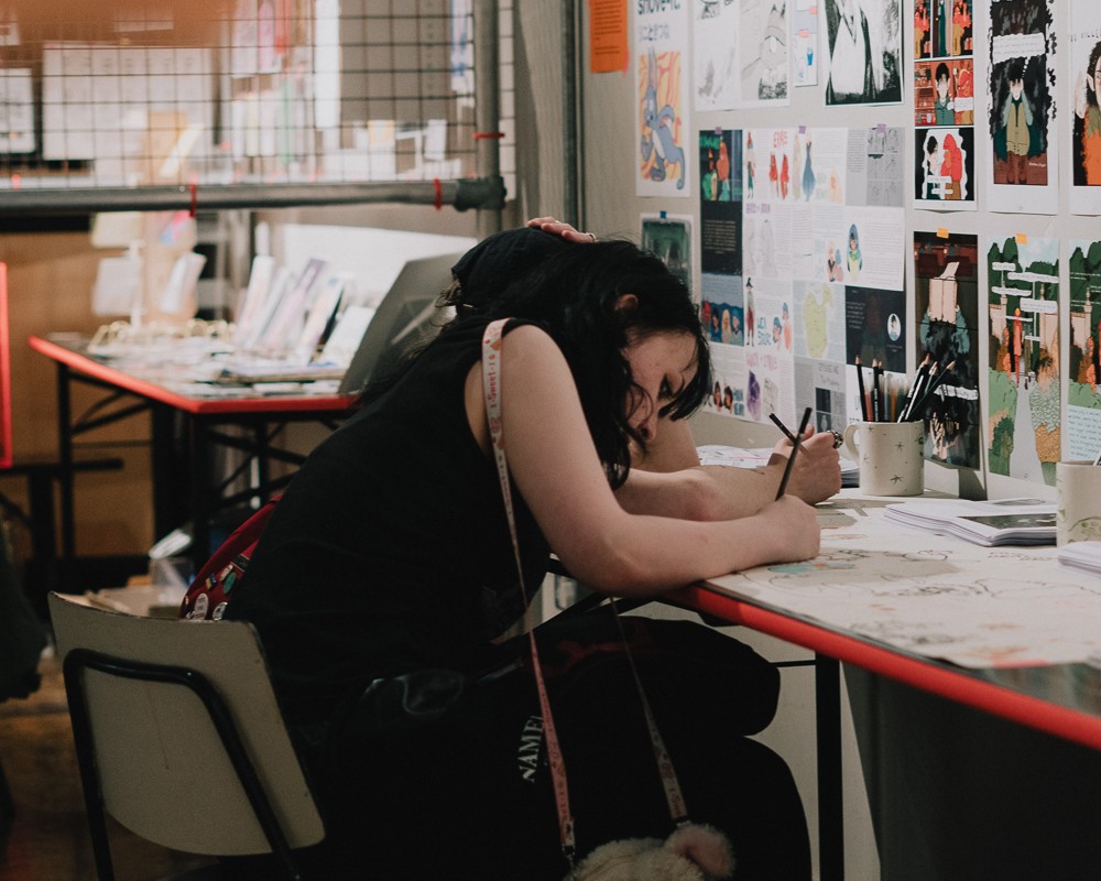 A student sat at a desk drawing