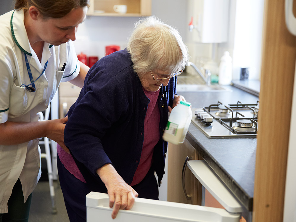 Elderly patient retrieving milk from fridge