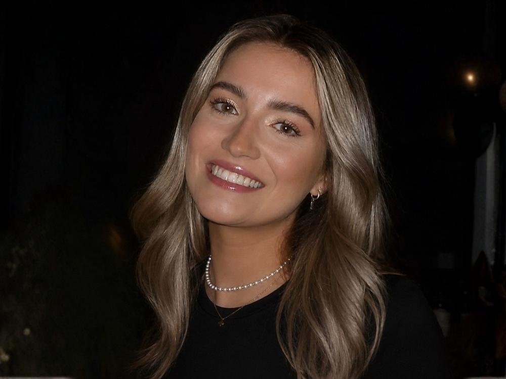 Headshot of a smiling woman against a black background