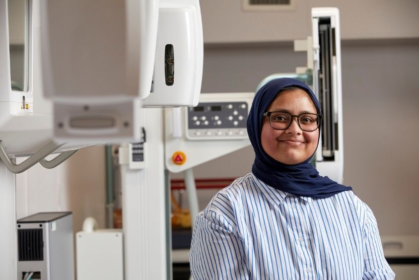 Women smiling standing in front of medical equipment