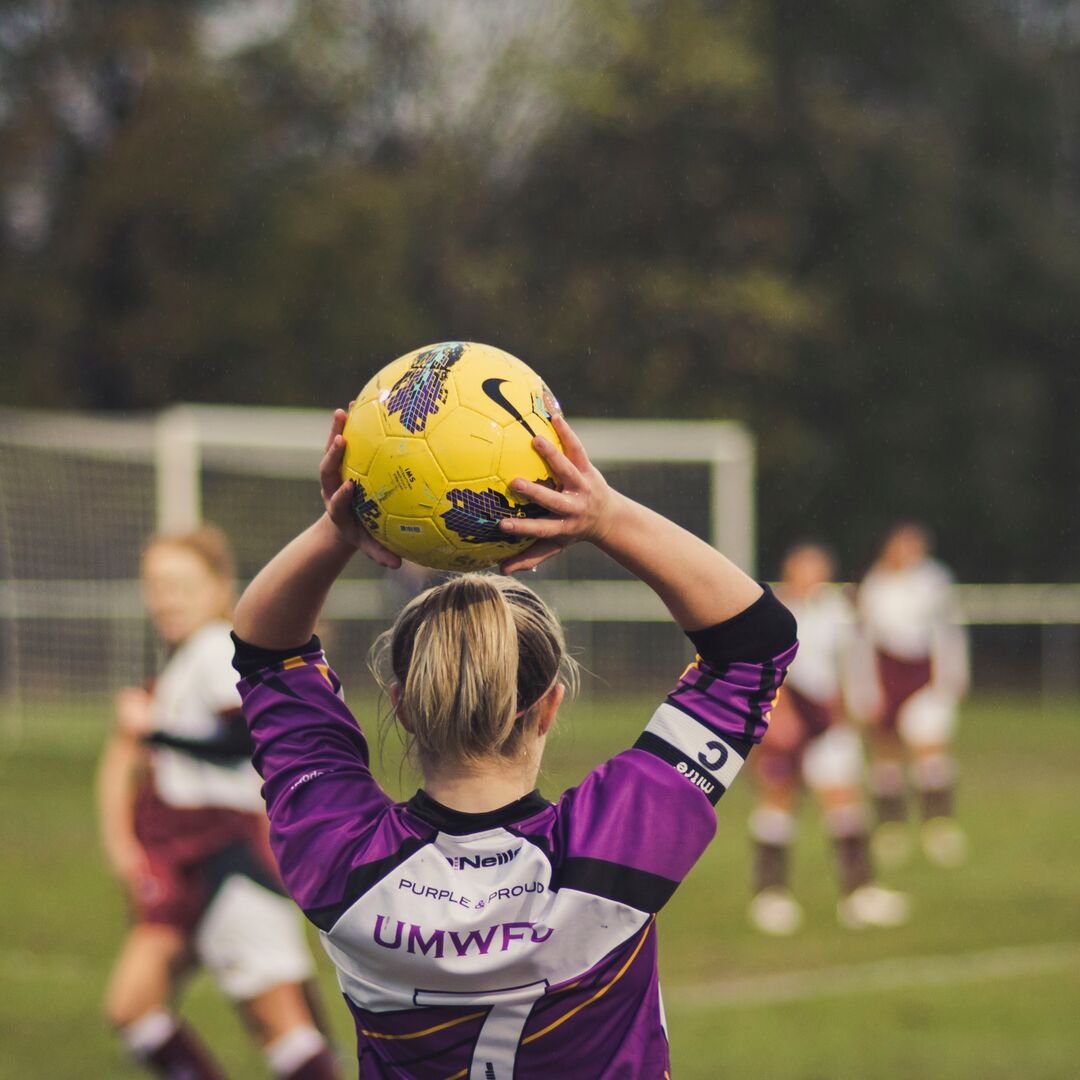 Photo of a female football player holding a football