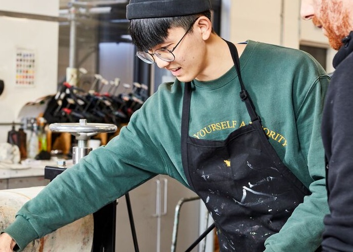 Male student screen printing with a lecturer