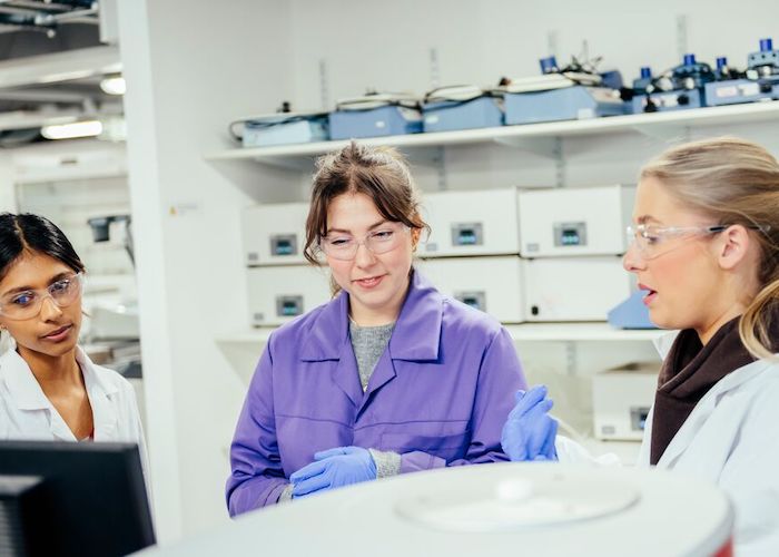 Three female students working in a lab