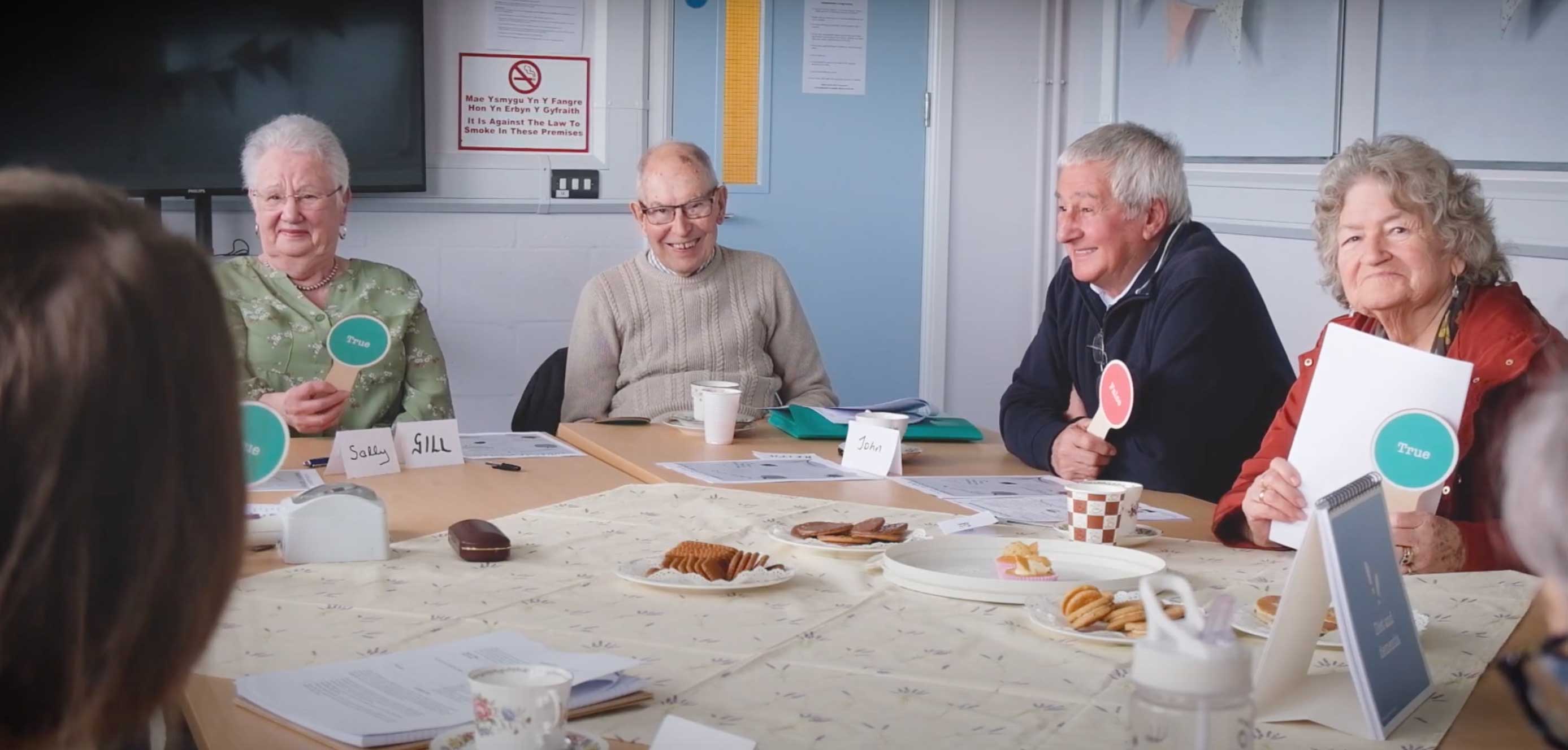 People sit around a table with the Journey Through Dementia kit