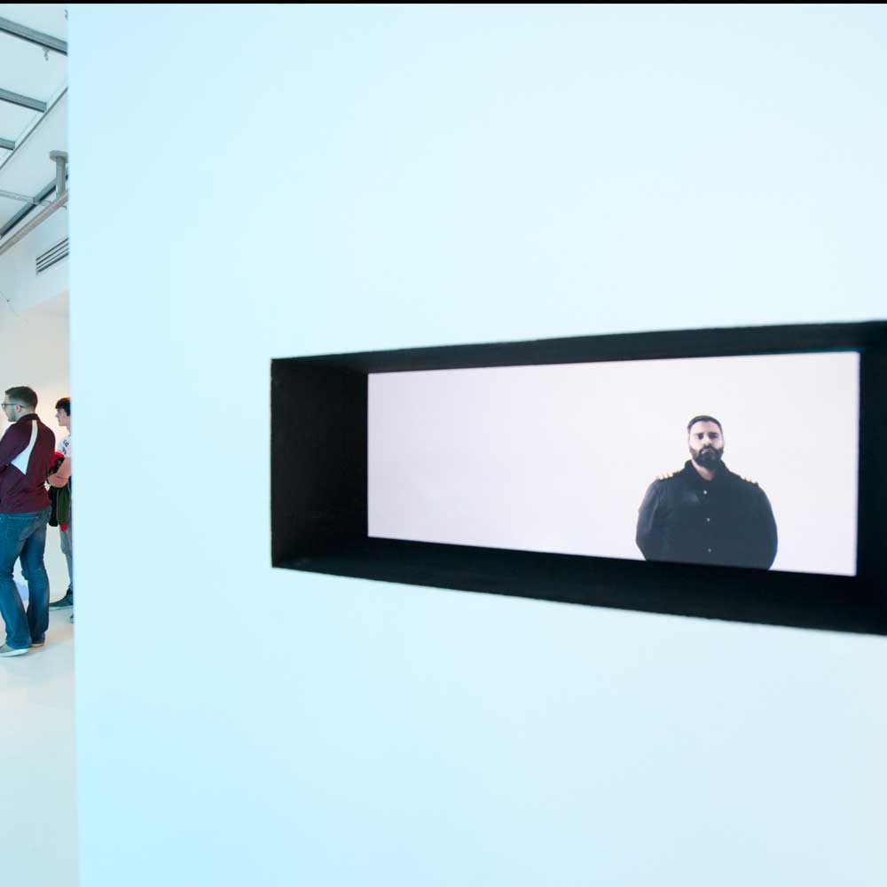 Installation image of Mirror II by David Cotterrell - An image of a man is displayed on a screen.