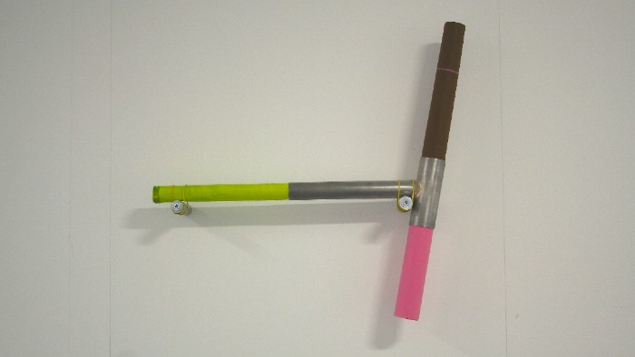 A piece of bicycle frame coloured with green, pink and black.