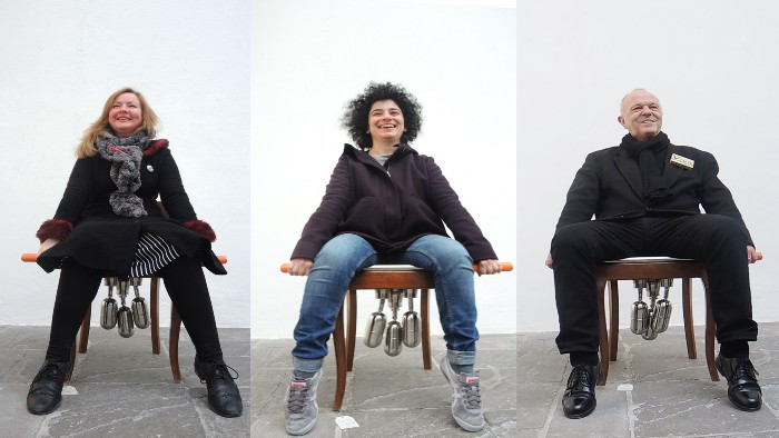 Two woman and a man sit in the chair of choices from the Domestication project