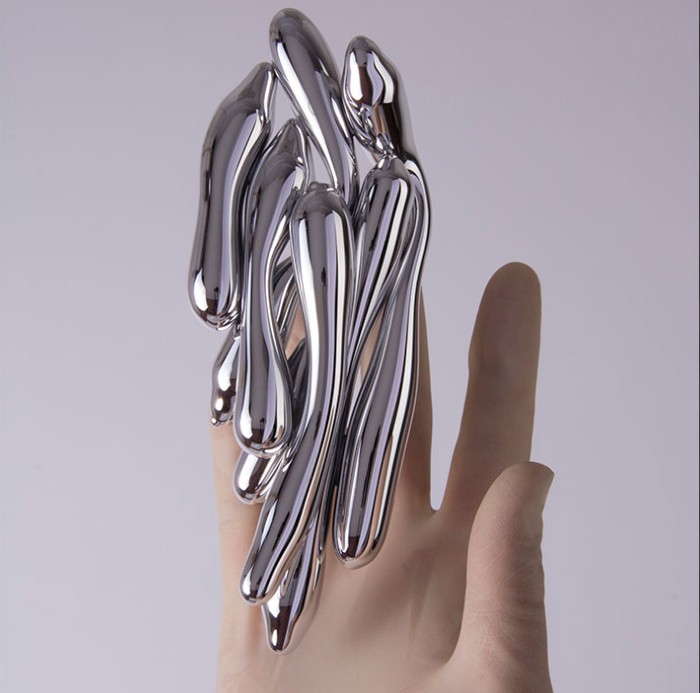 Piece of art from excessories project. Hand holding sliver material.