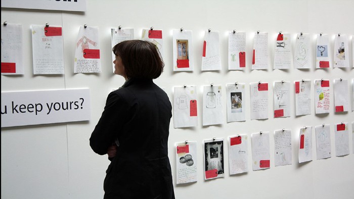 A woman looking at images in the Objects in Purgatory gallery display