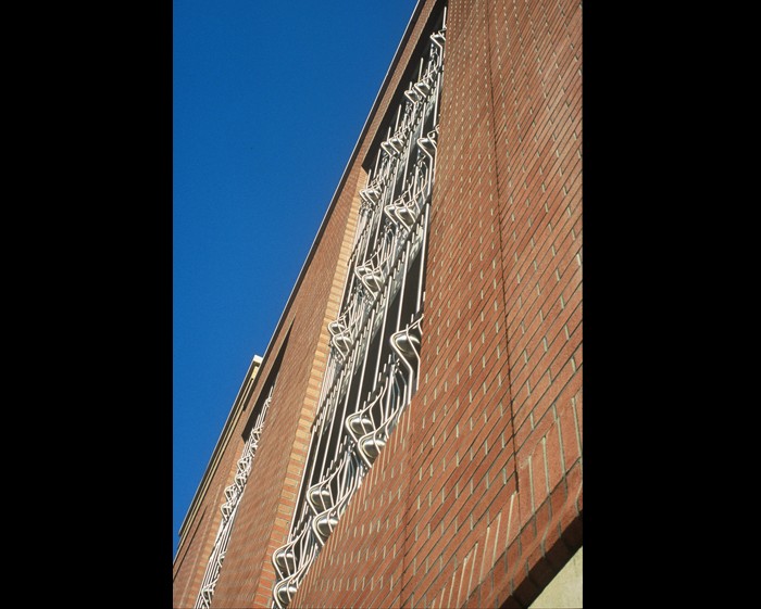 A piece of metalwork on a Sheffield city centre building. Bars of steel that warp over spherical balls at the top middle and bottom of the piece