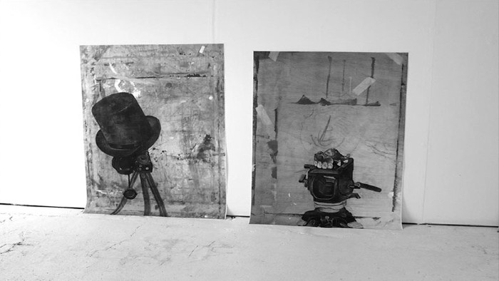 Two piece from the imposter series project displayed in a gallery. The pieces are top hat on a camera and the dentures on top of a camera