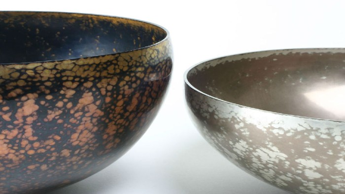 Two bowls made using Japanese alloying and patination. The bowl on the left is larger with a black and rust colouring and the smaller one on the right is sliver and pewter colour