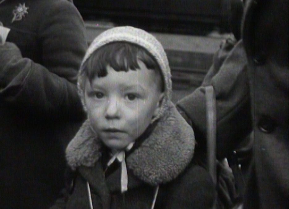 Still from Virginia Heath's 'We Are All Migrants' - a young boy arrives by train