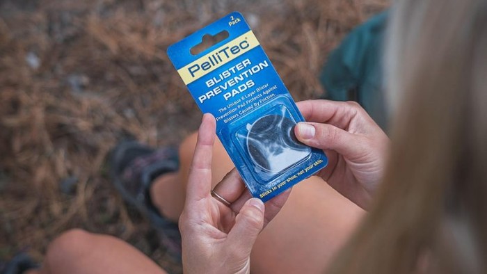 Woman on a hike holding the PelliTec blister pad product