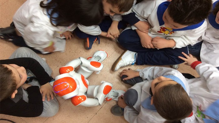 A group of children playing with a small humanoid robot