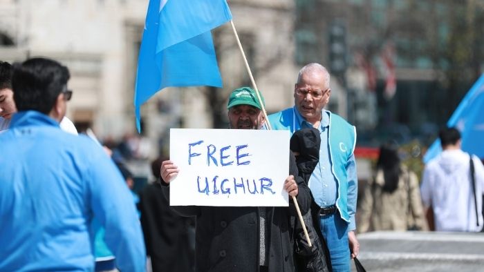 A man with a sign saying Free Uighur