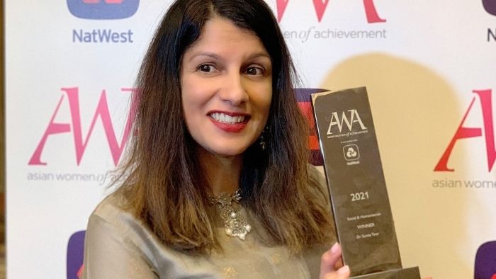 Dr Sunita Toor posing with an Asian Women of Achievement Award
