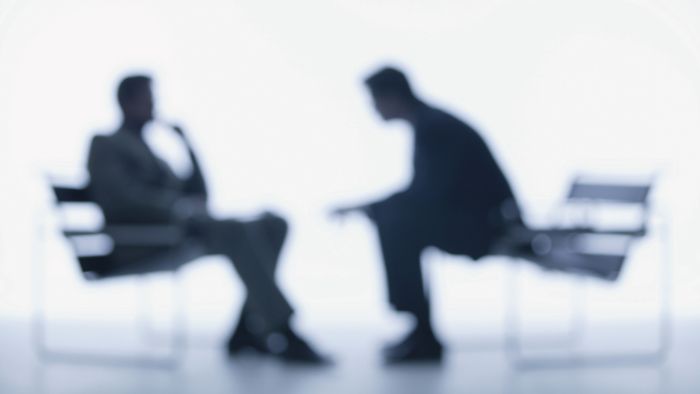 Blurred photograph of two men sitting on chairs