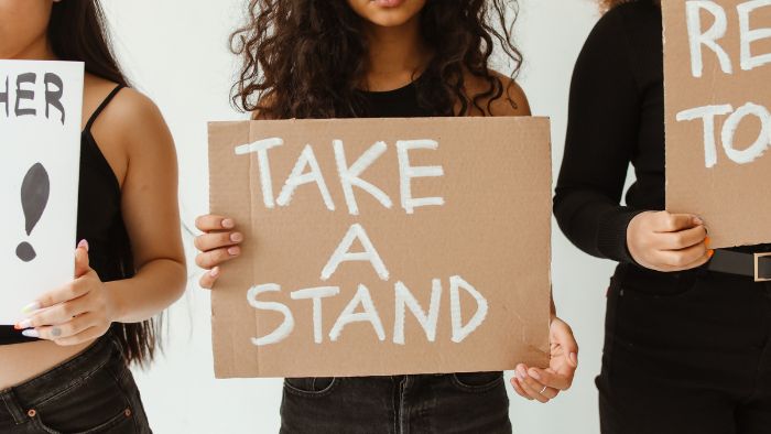 A woman holding 'Take a Stand' sign