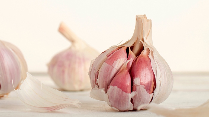 Garlic bulb with cloves showing and partially peeled