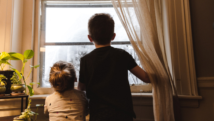 Children looking out of window in winter