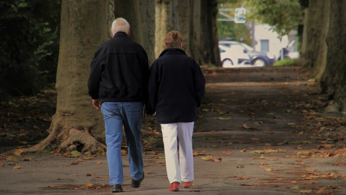 An older couple walking in a park