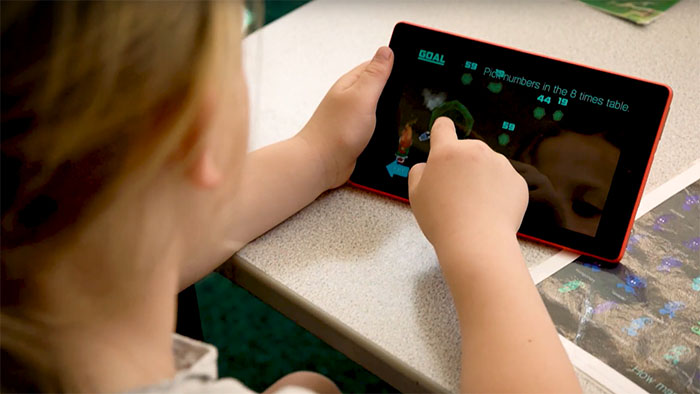 Girl playing a maths game on a tablet