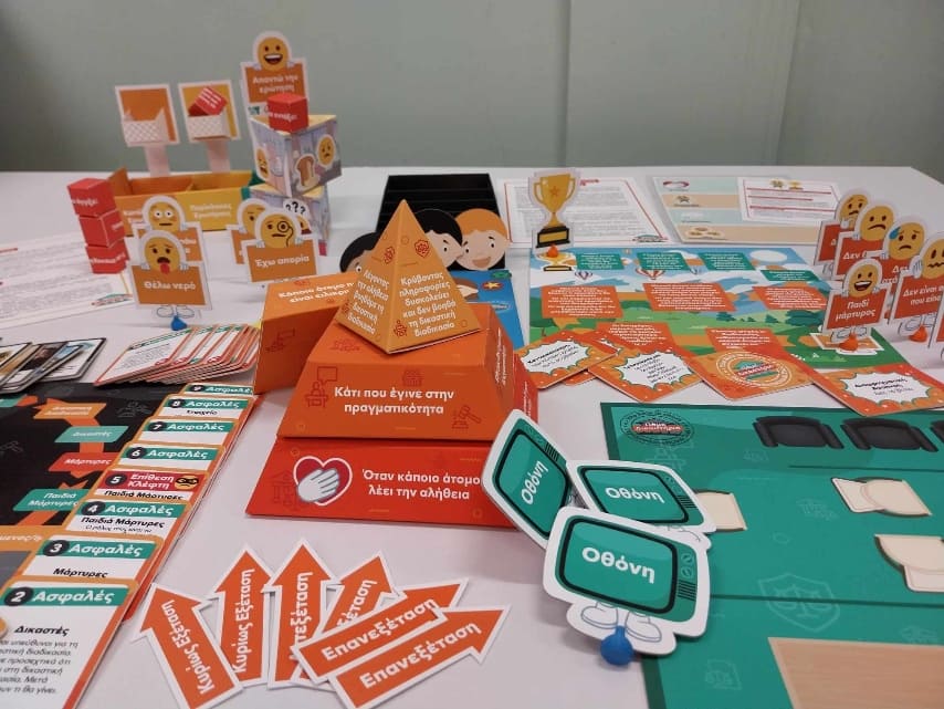 Image displaying colourful elements of the kids in court board game. Game components include cards, character cards and arrows
