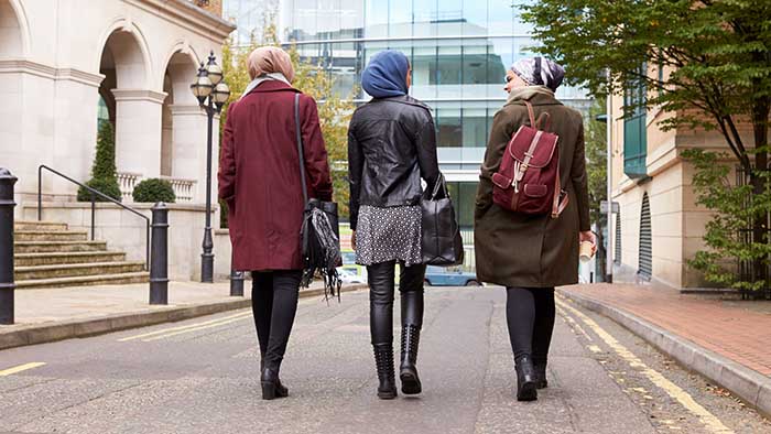 Three women walking down a street